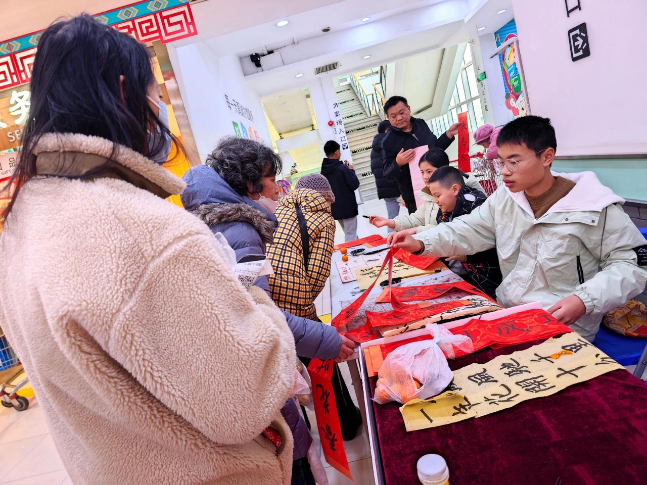 临近2026年春节，传统文化活动越来越多，钟秀文化堂的学生们在大润发写春联送福，