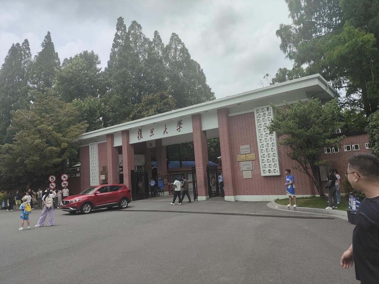 镜头定格复旦大学经典校门，红砖白檐古朴厚重，“复旦大学”四字笔墨隽永。
门内古树