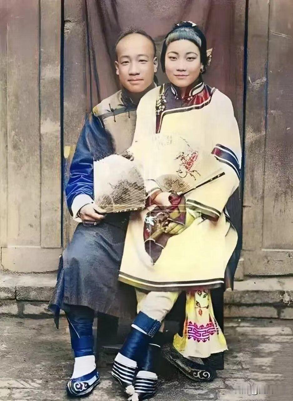 满清富裕人家的一对小夫妻，穿戴精致，女的裹小脚，个不高，有种小家碧玉的感觉！