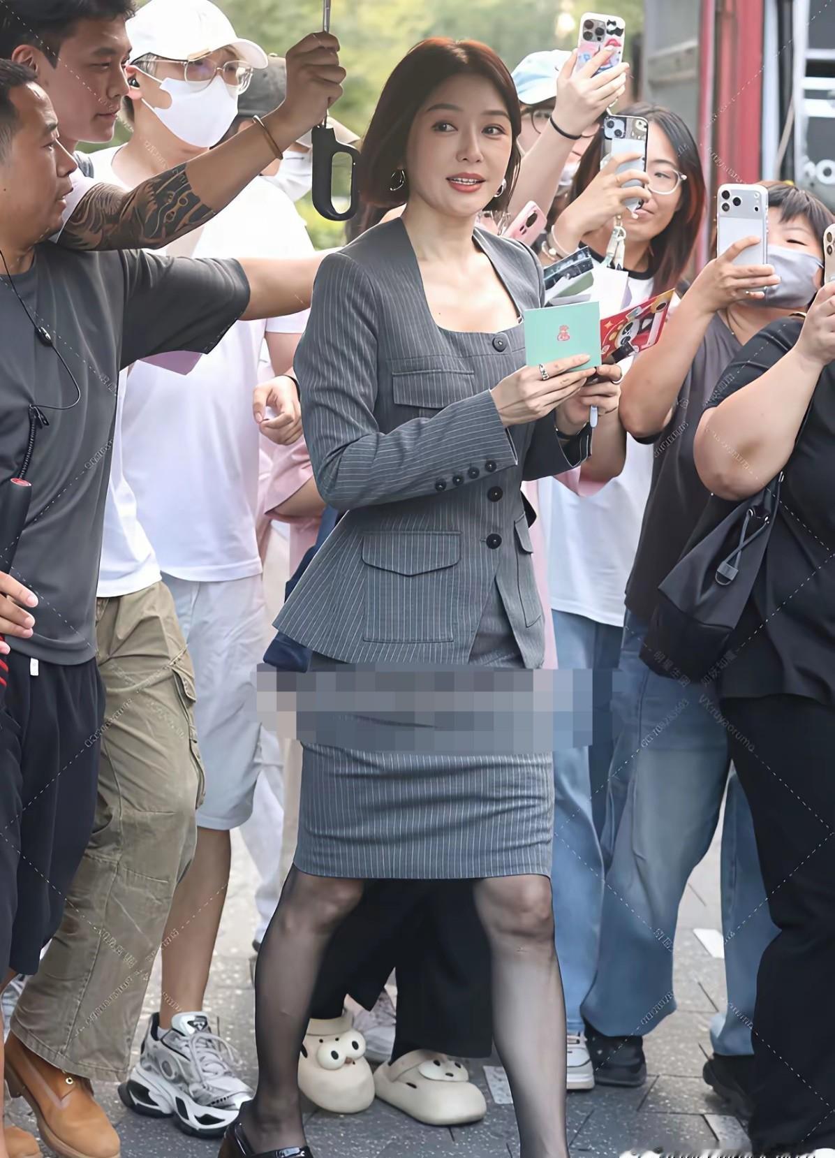 活动现场，秦岚身边围了十二个黑衣保安，隔壁顶流只有三个。
品牌方直接调了双倍人力