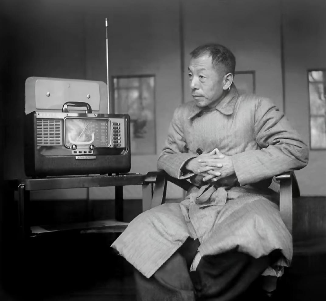 1957年，台湾，某处山间一间住处，

张学良坐在椅子上，桌子上面是一台收音机。