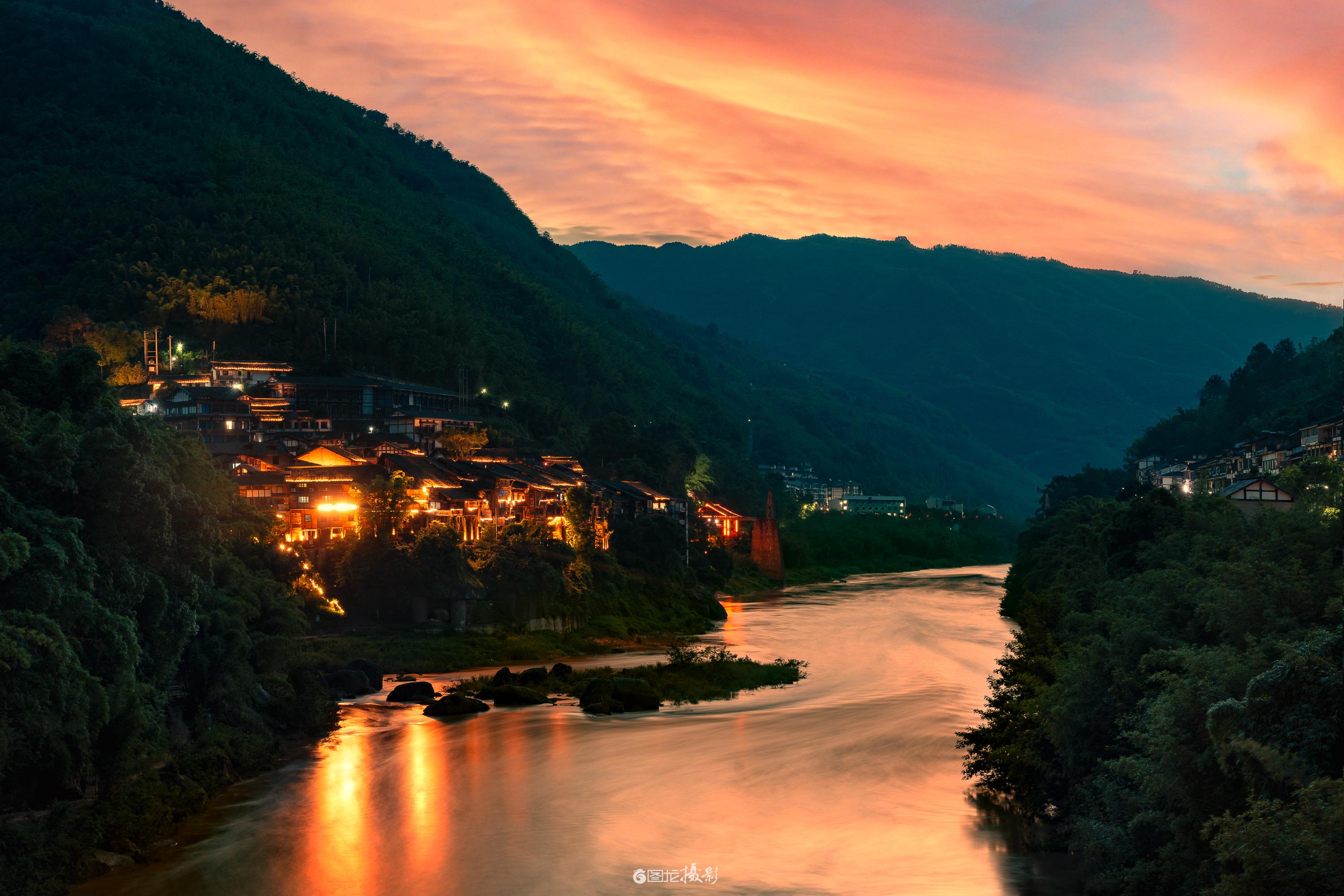 丙安古镇的暮色把晚霞揉进河与烟火里，橙云裹着山尖，古镇的暖光浸在赤水河...