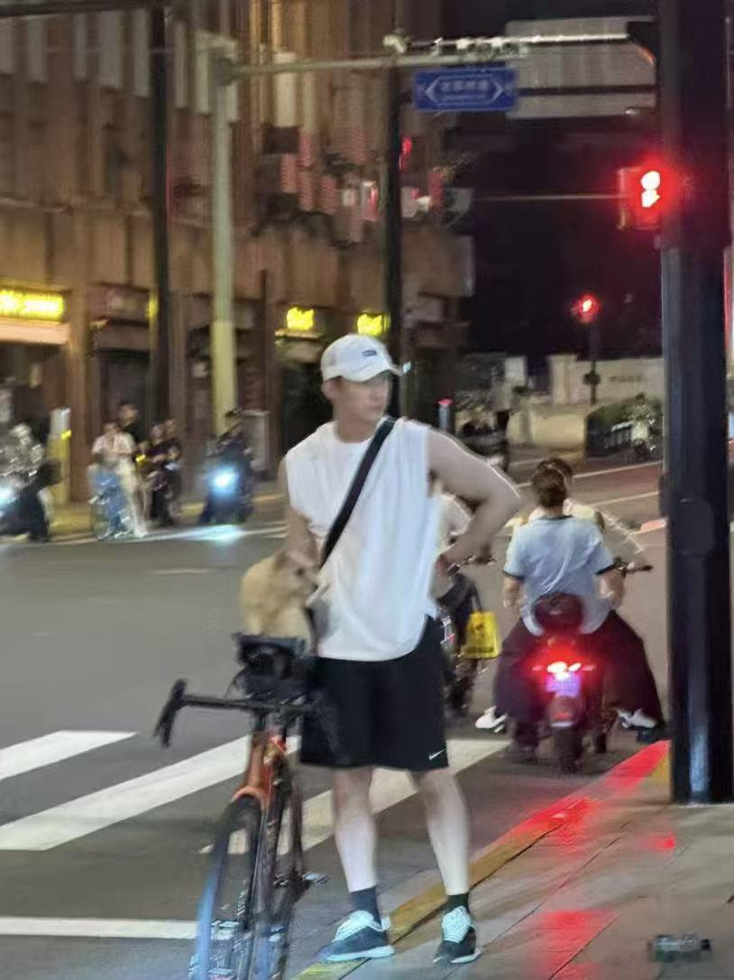 黄景瑜单手拎起自行车别人搬自行车费劲十足，黄景瑜单手操作游刃有余。一身简单穿搭，