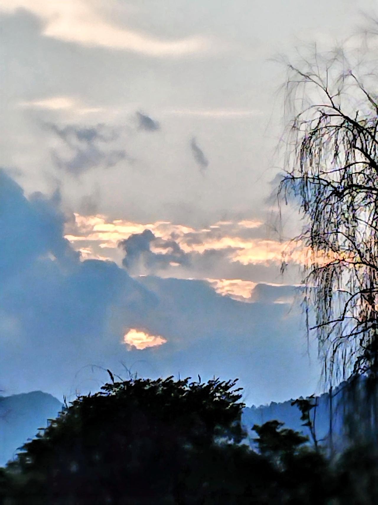 云海翻涌，夕阳的余晖倾洒在山间，静谧又美丽。那绝美的云海，宛如一条条轻柔的丝带，