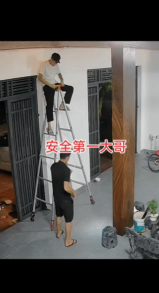 下面那个人究竟起什么作用？
他不应该用手扶着梯子吗？
在合梯上干活的那个人可真够