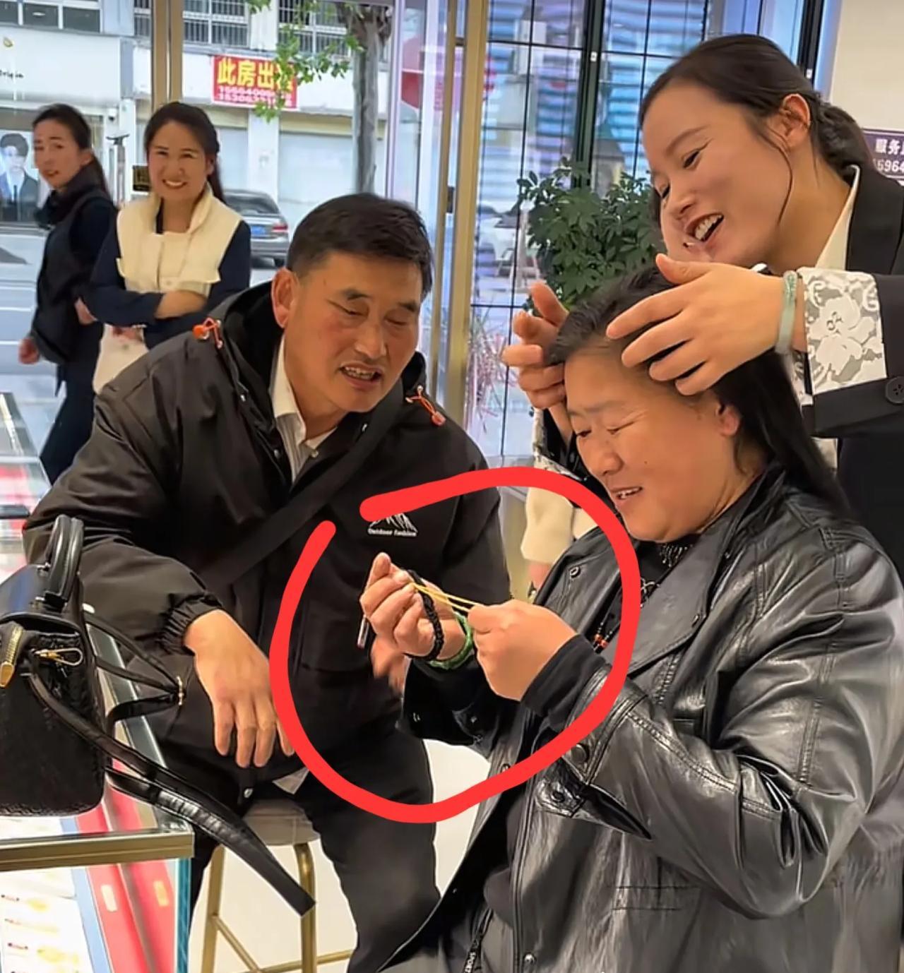 他直接把金项链戴到老婆脖子上，动作熟练得像给自家麦苗浇水。
店员刚报完价，大衣哥