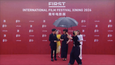 张颂文给女主持撑伞 张颂文在FIRST红毯上接过雨伞后，也让一起走红毯的徐帆和女
