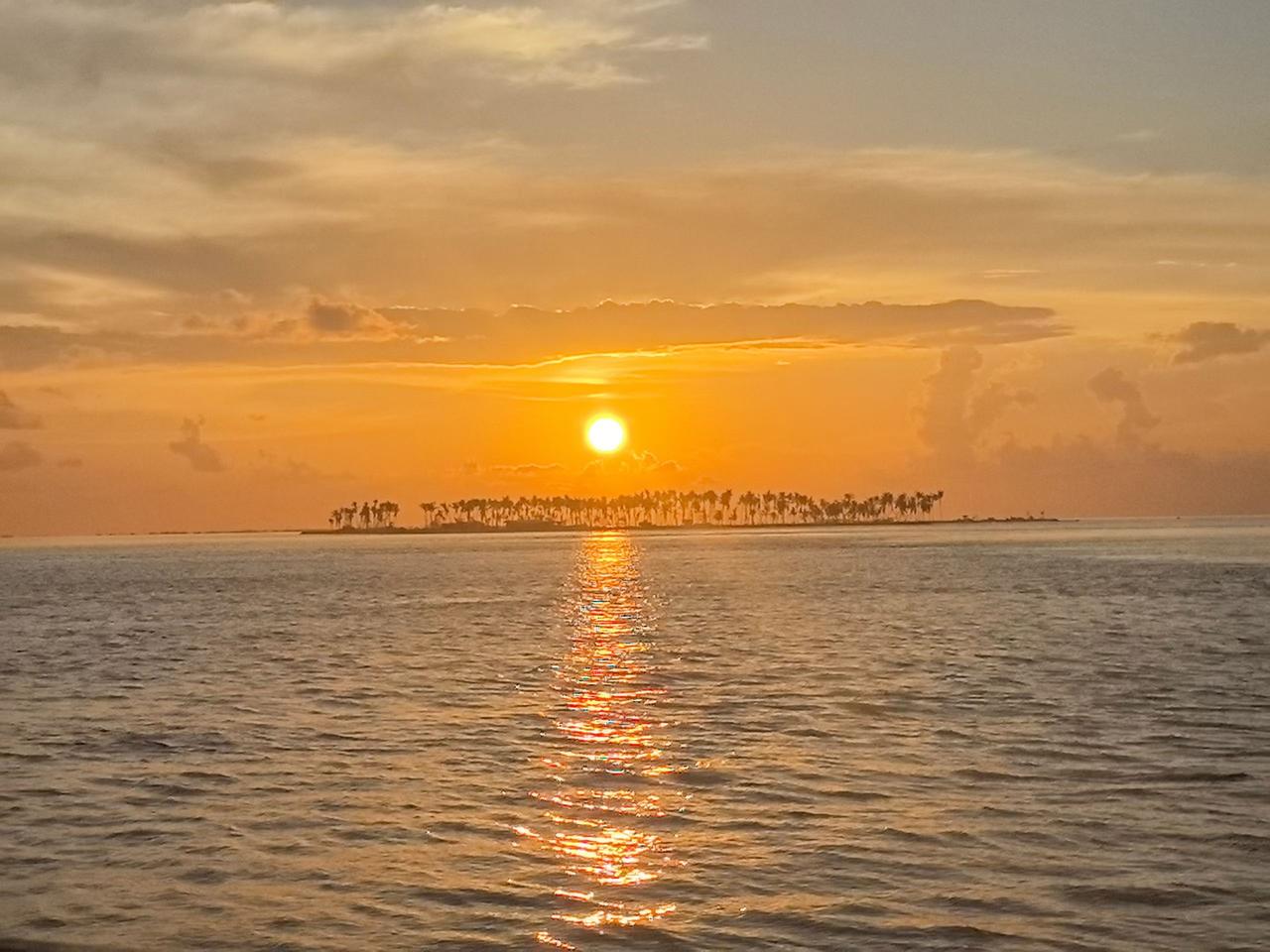 暮色漫过海面的时候，世界就慢下来了。

橘红色的落日悬在水天相接的地方，把整片天