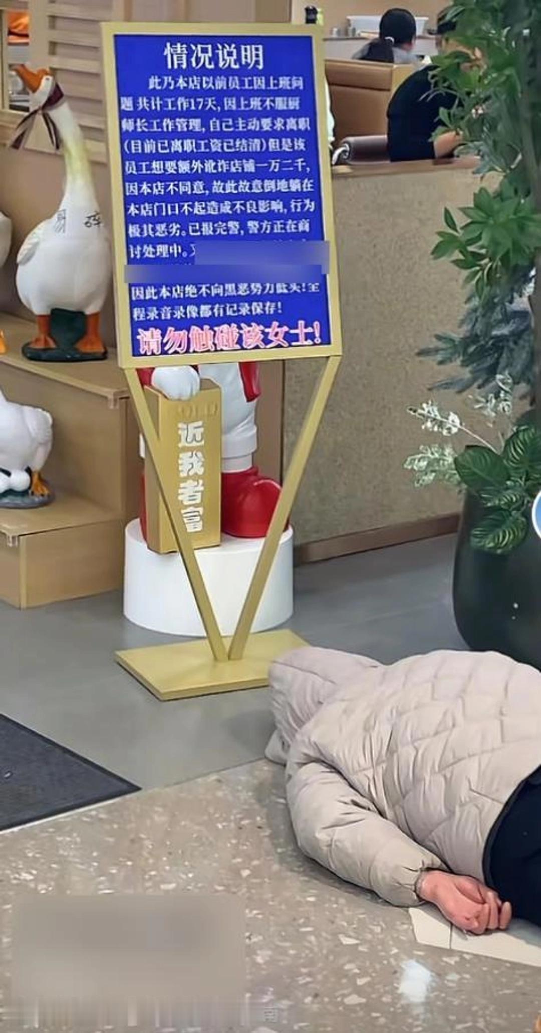 1月12日，河南商丘吾悦广场的一幕让路人纷纷驻足：一名女子用帽子蒙头躺在餐馆门前