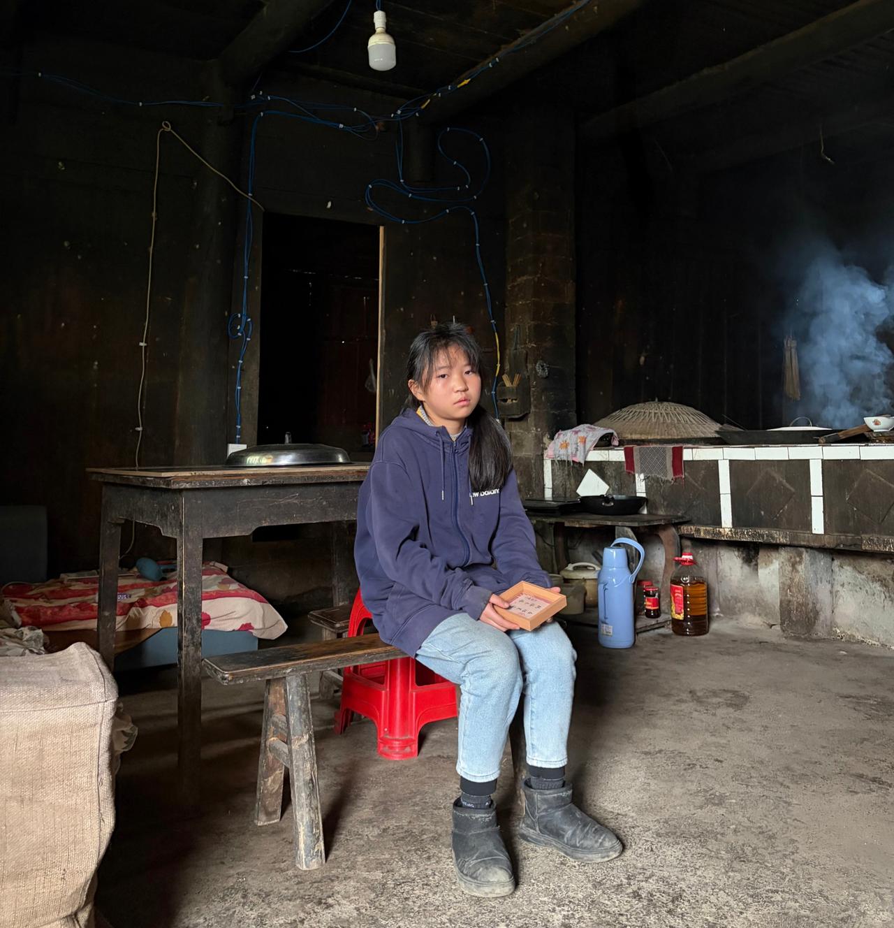 什么样的女孩你看一眼就会心动武陵山里的一位女孩，她坐在屋里的长凳上，一脸无奈的表