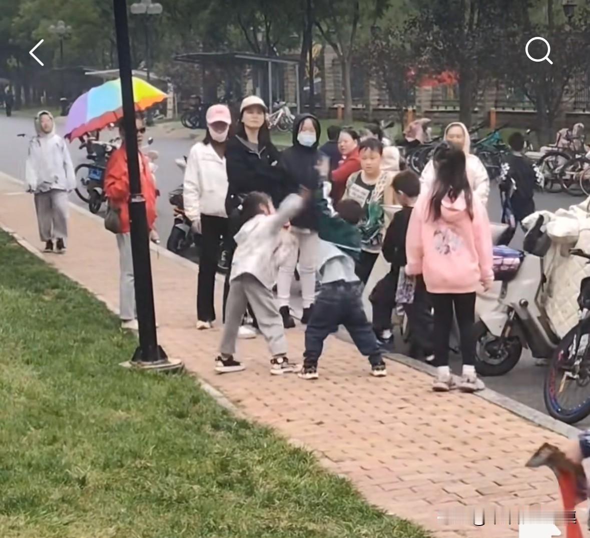 两个小学生在路边发生冲突，于是打了起来，小男孩的妈妈不知道出于什么心理，大声喊：