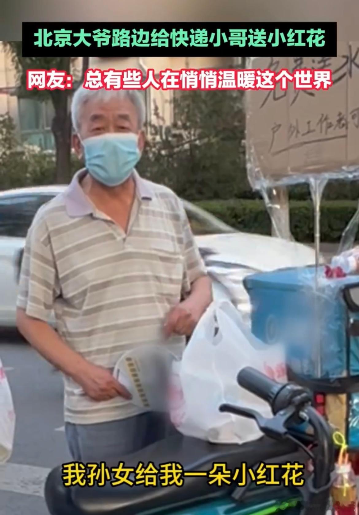 #北京大爷路边给快递小哥送小红花# 小小的红花，大大的爱！大爷的行为让人看到了人