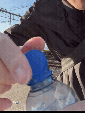 游客新奇欧洲的连体瓶盖，认为设计很好，但是他喝水的时候，明显需要多一个手指配合。