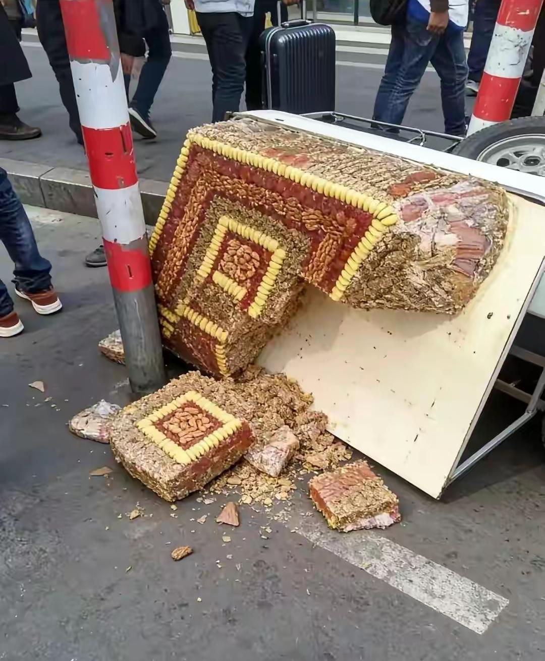 一男子倒车时没注意，不小心就把路边卖切糕的小摊车给刮倒了，一瞬间，原本整齐码在推