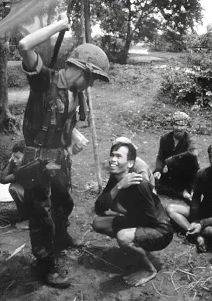 60年代，一名越南俘虏，被美军虐待时，留下的一张镜头，照片中的越军士兵赤着脚，蹲