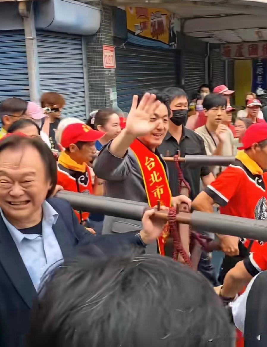 王世坚高兴地为蒋万安扶着轿杆，不停地给周围的群众挥手致意。

看来王世坚并不讨厌