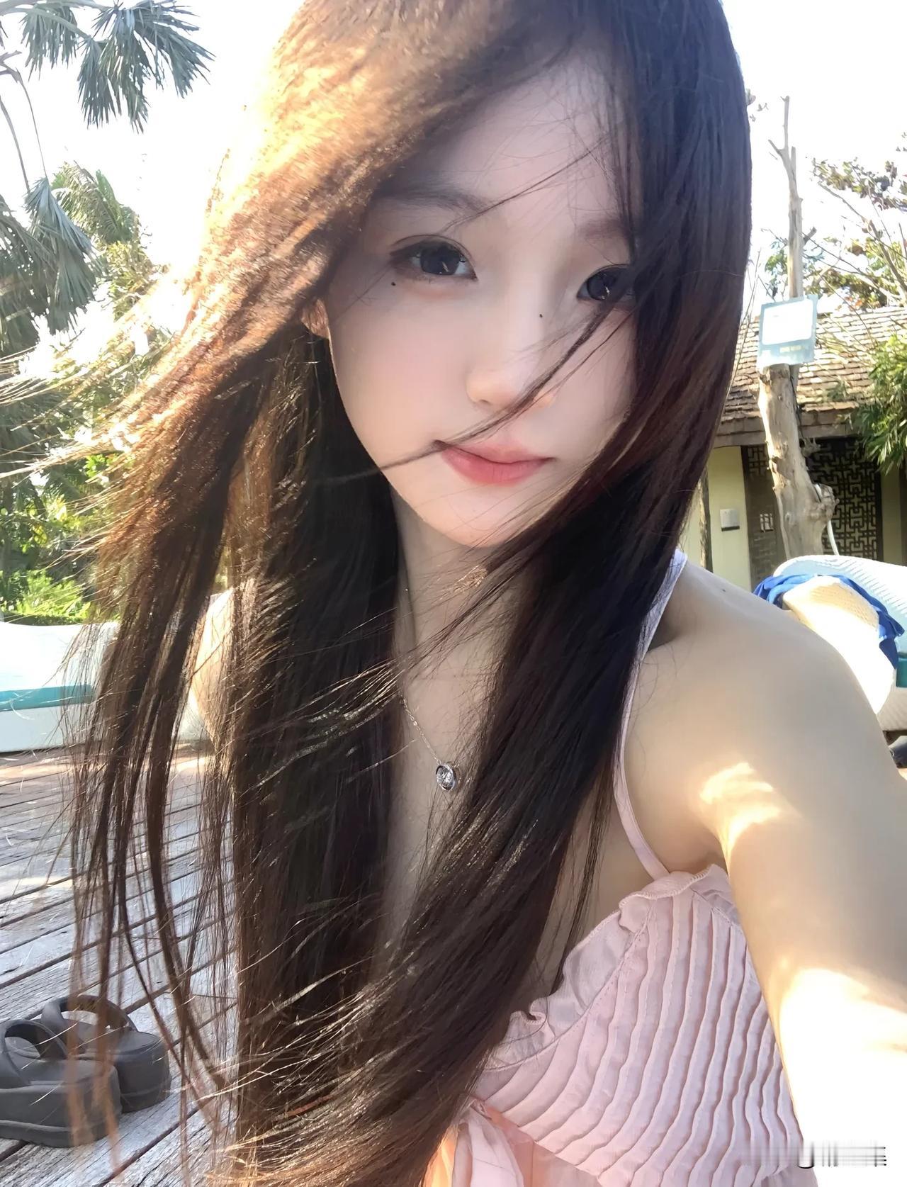 阳光下的甜美自拍，长卷发随风飘逸，粉色吊带裙清新动人。