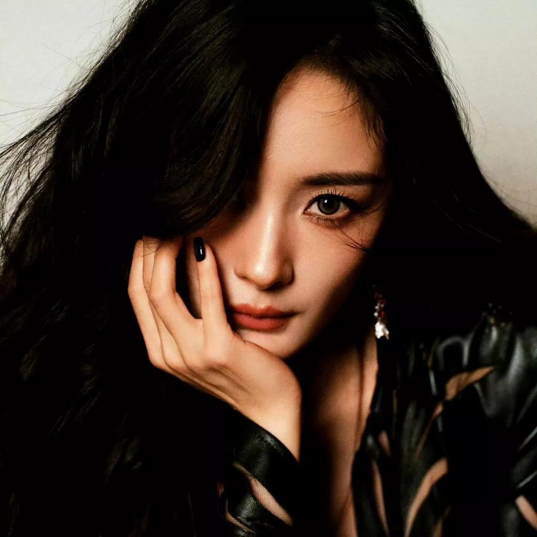 冷艳黑发少女，眼神深邃迷人，指尖轻触脸颊，散发神秘气息。