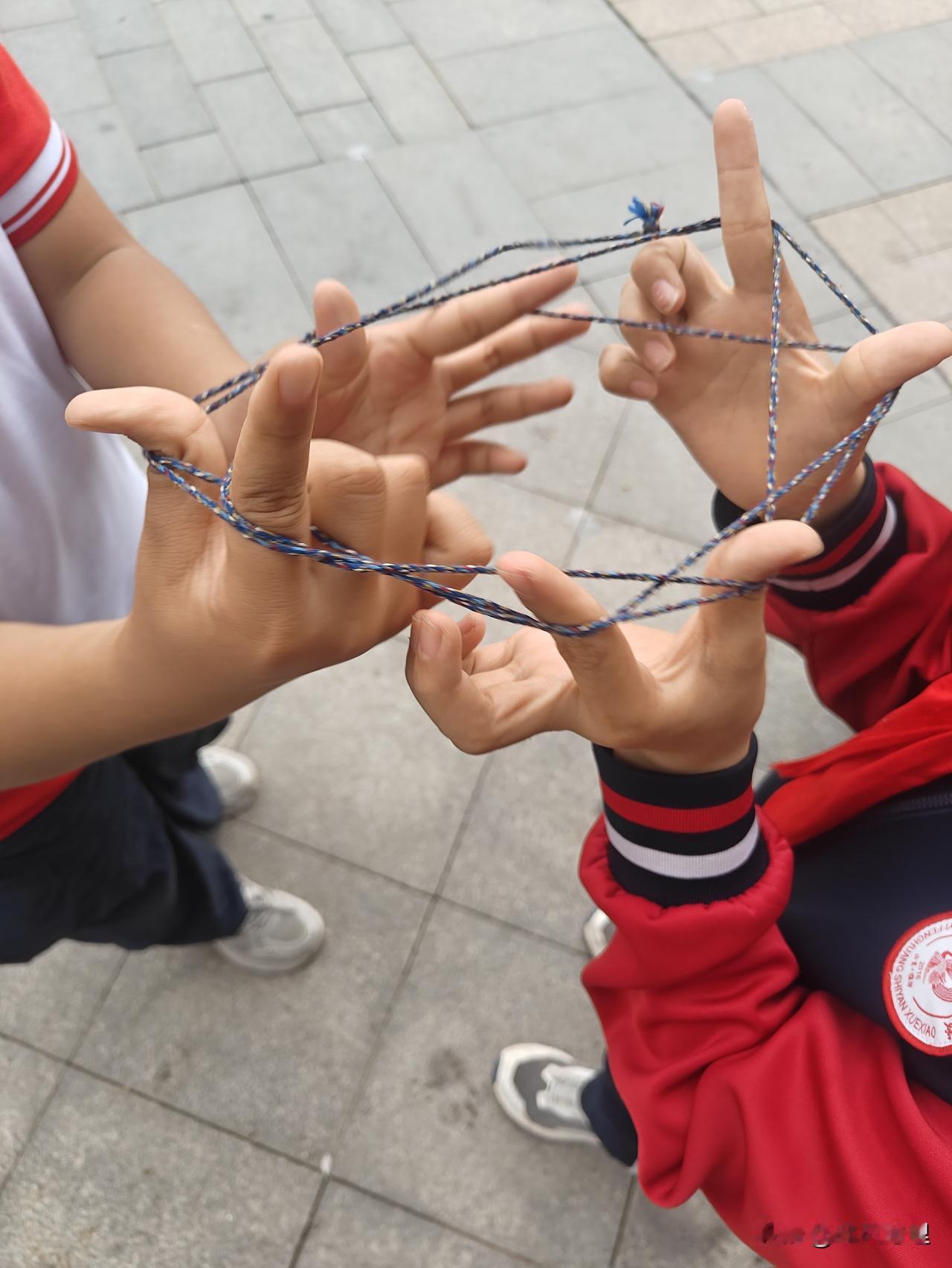现在的小孩又流行翻花绳了！
今天体育课自由活动时间，发现有几个小孩在玩翻花绳，很