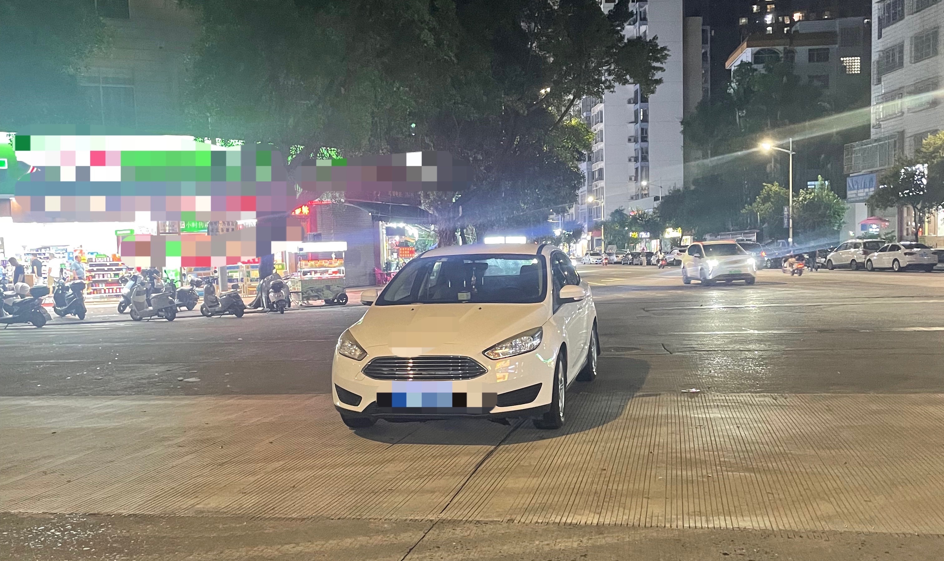7月21日晚，玉林金玉路一十字路口变成了停车场 有一辆车牌号码为桂Ku5的白色小