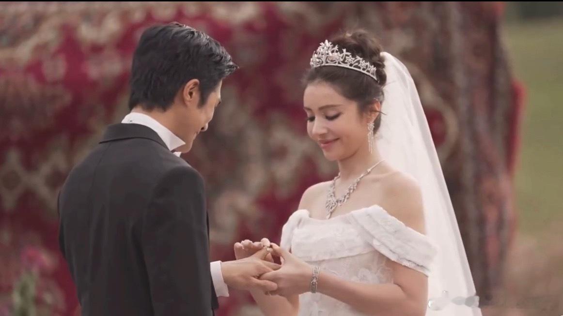 麦迪娜给姜潮戴戒指塞不进去麦迪娜拿婚戒往姜潮手上套，戒指卡在指节怎么都推不下去。