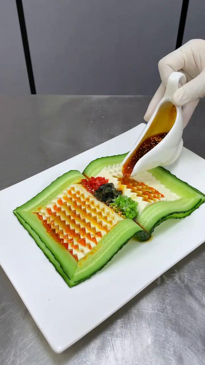 锦绣玉书豆腐。
·嫩豆腐刻出锯齿状，切薄片，做出书本造型。
·黄瓜切连刀片，摆出