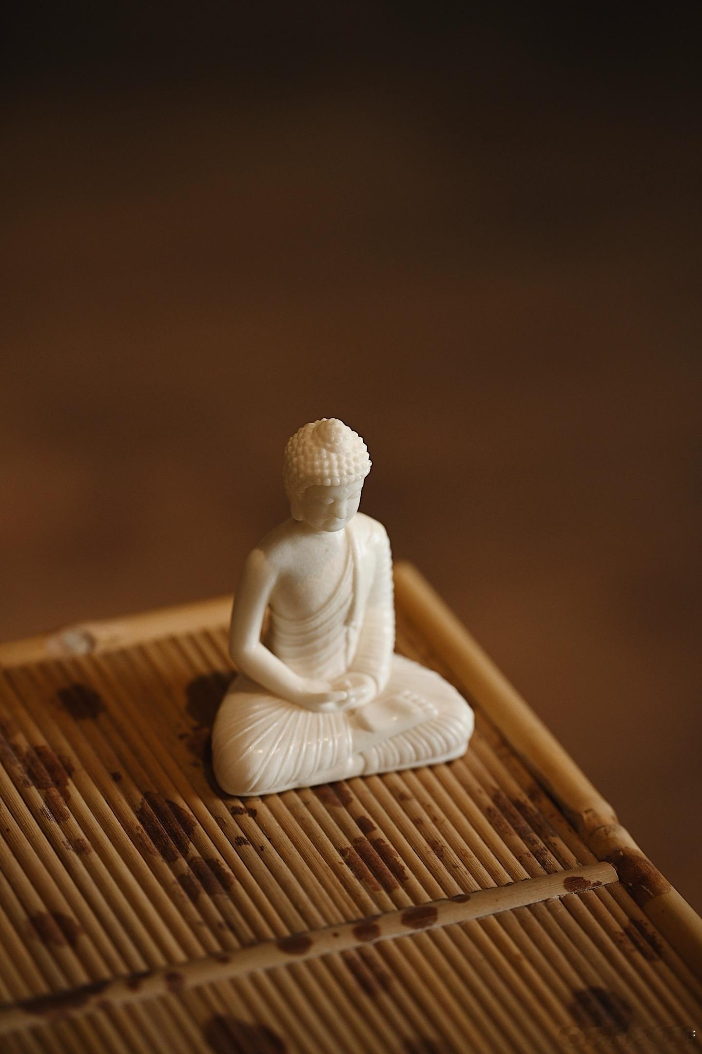 鹿角“释迦牟尼”料质白润，雕刻佛陀结跏趺坐，禅定印安守于腹，面相慈和沉静，衣纹流