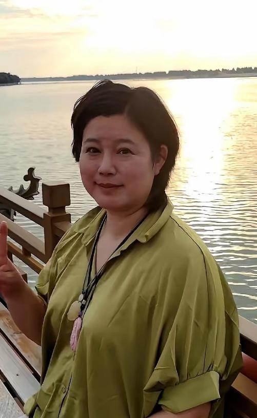 要是没人提醒，打死我也不敢信。眼前这个挤着眼睛、双下巴若隐若现的短发大姐，竟然是