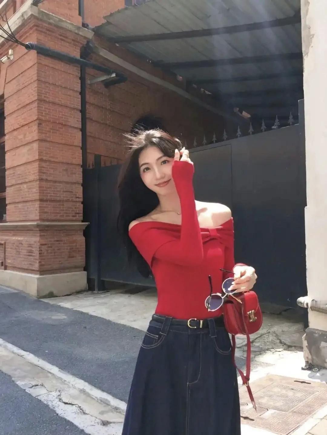 晒图笔记大赛元气少女轻抚发梢街头摆姿，红色露肩上衣搭配牛仔裤👖，活力满满。