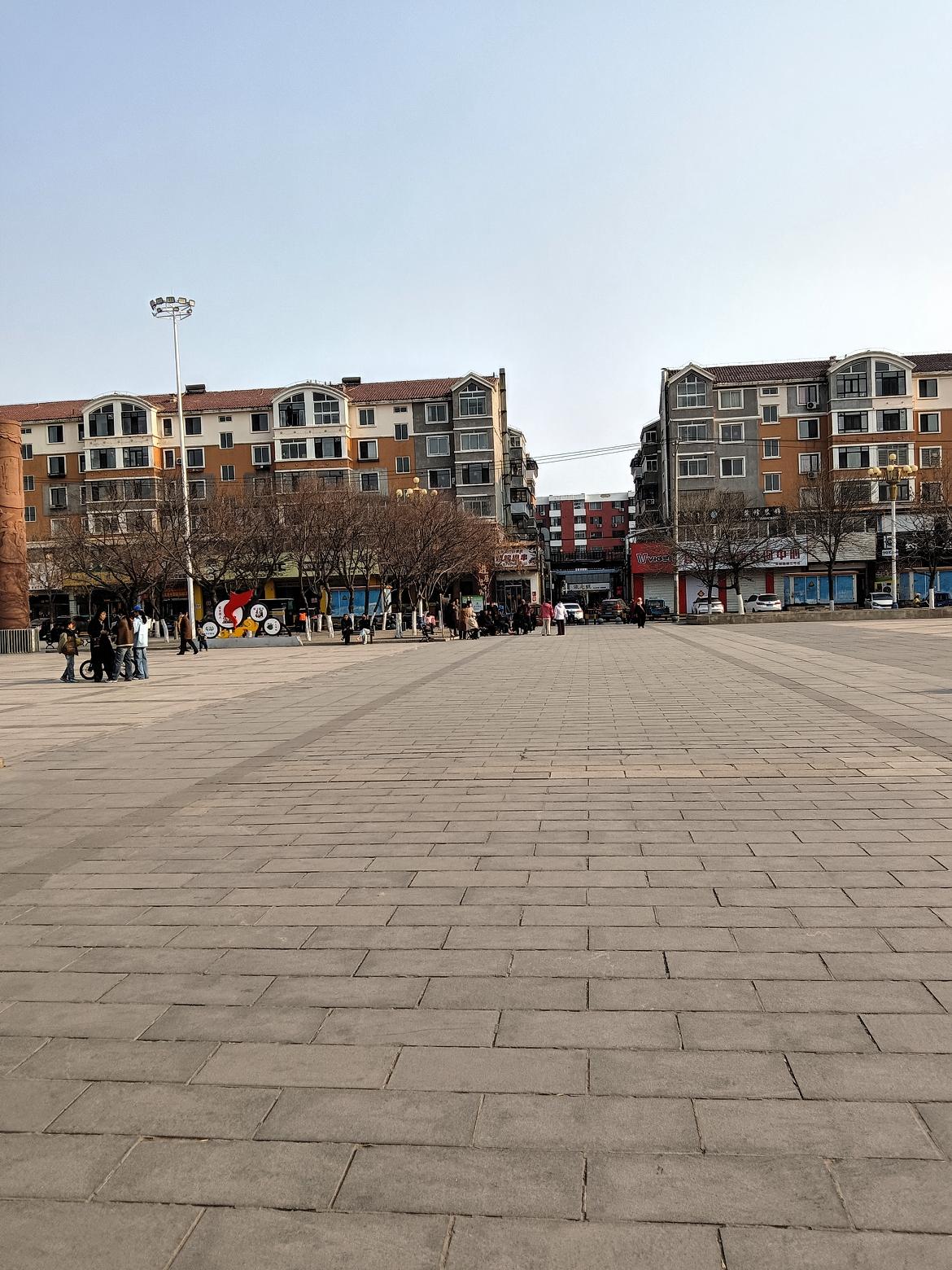 城市广场的悠闲时光，阳光洒满广场，人们悠闲地散步。