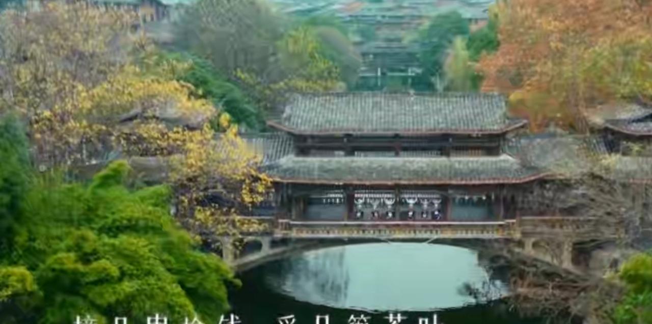 古色古香的廊桥静卧在碧波之上，周边林木层林尽染，中式建筑的雅致与自然山水的秀美在