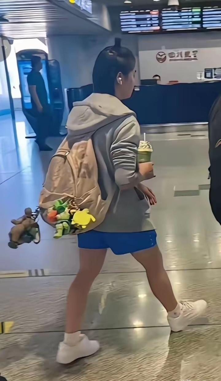 全红婵在机场被路人偶遇，一身休闲装扮，灰色卫衣配蓝短裤，简单小白鞋，再扎上标志性