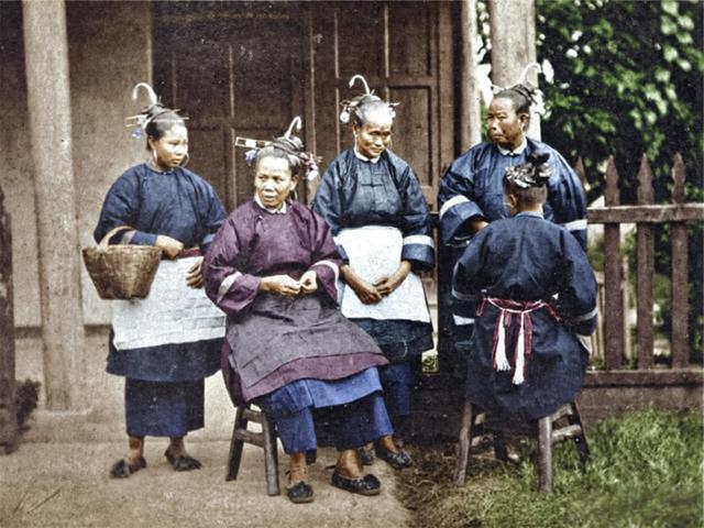 这是一张1880年福州茶园周边女性日常的影像，照片取景于茶园旁的民居檐下，她们后