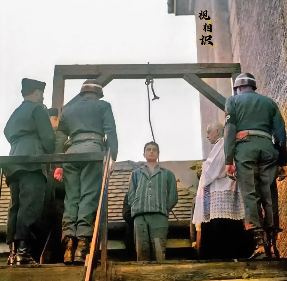 1946年，达豪集中营看守西蒙·基恩被处以绞刑时的场景，镜头中他站在绞刑台上，脖...