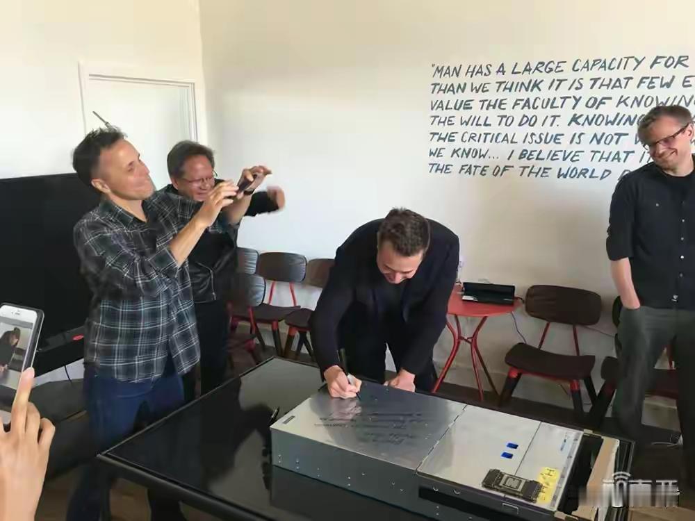 马斯克写字，黄仁勋笑眯眯给他拍照，看得出来他们俩关系很好呀。