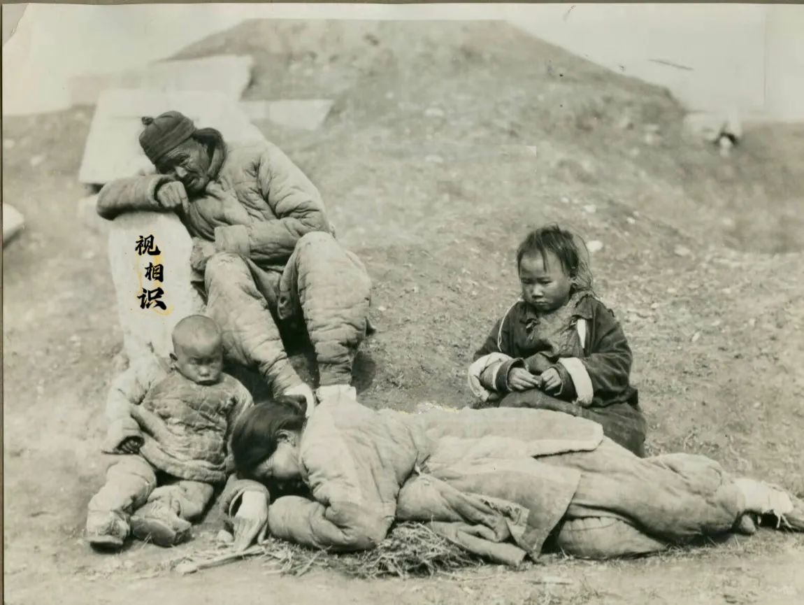 民国初年，一个逃荒四口的照片，画面中父亲和母亲都因为赶路和饥饿，已经体力不支，不...