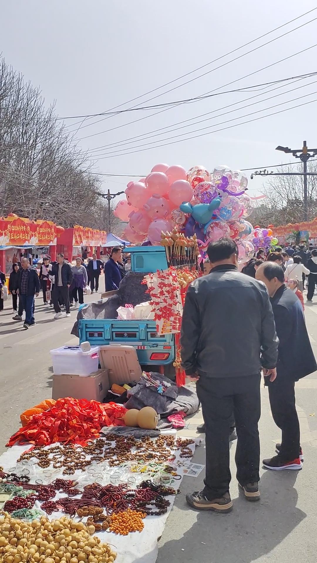 晒一晒随拍春日集市里，红绸与葫芦串起热闹，手串、气球藏着烟火气，人来人往间，都是