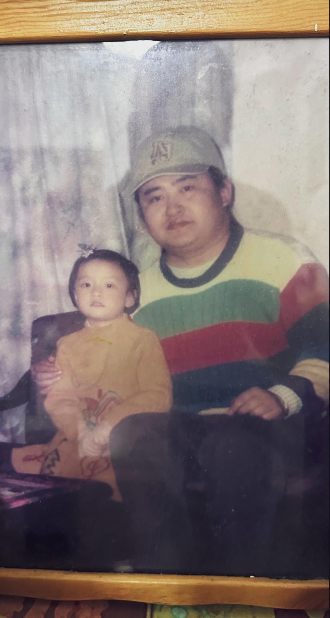 老照片中刘欢身穿颇有年代感的毛衣，戴着棒球帽，与小朋友一起留下的珍贵合影！