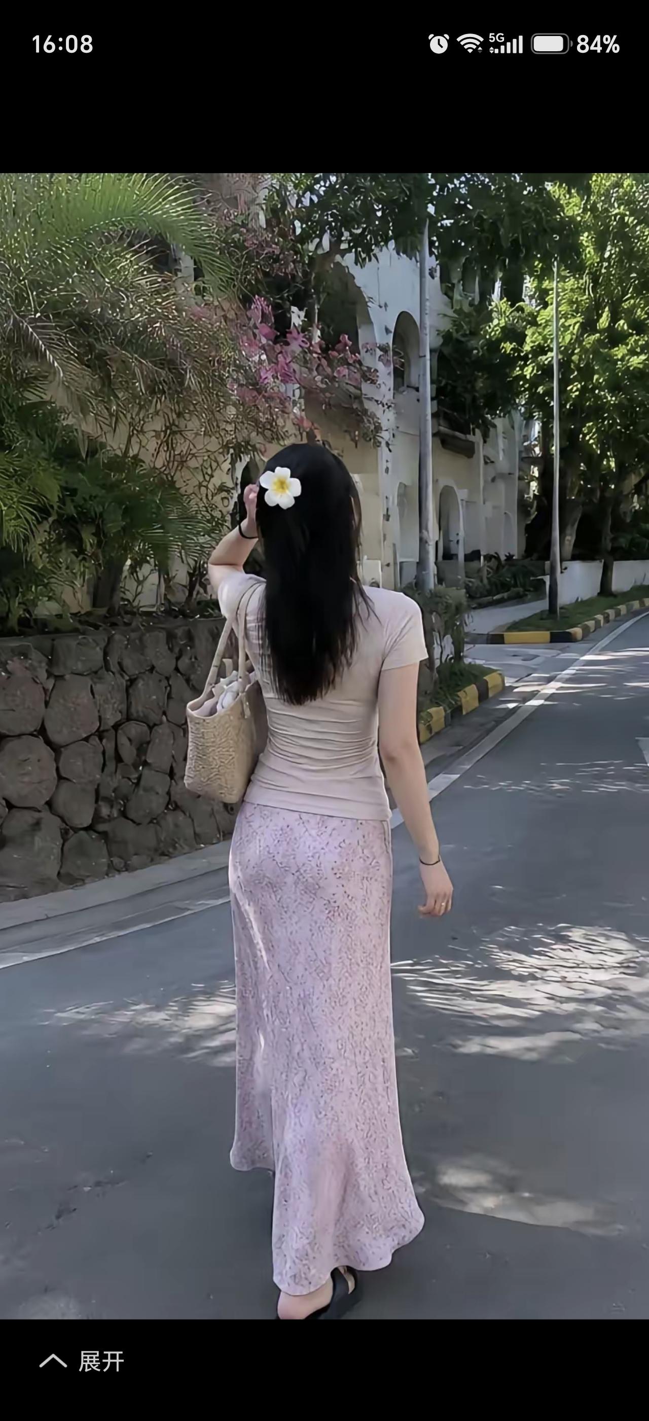 一位长发女士背对镜头走路。