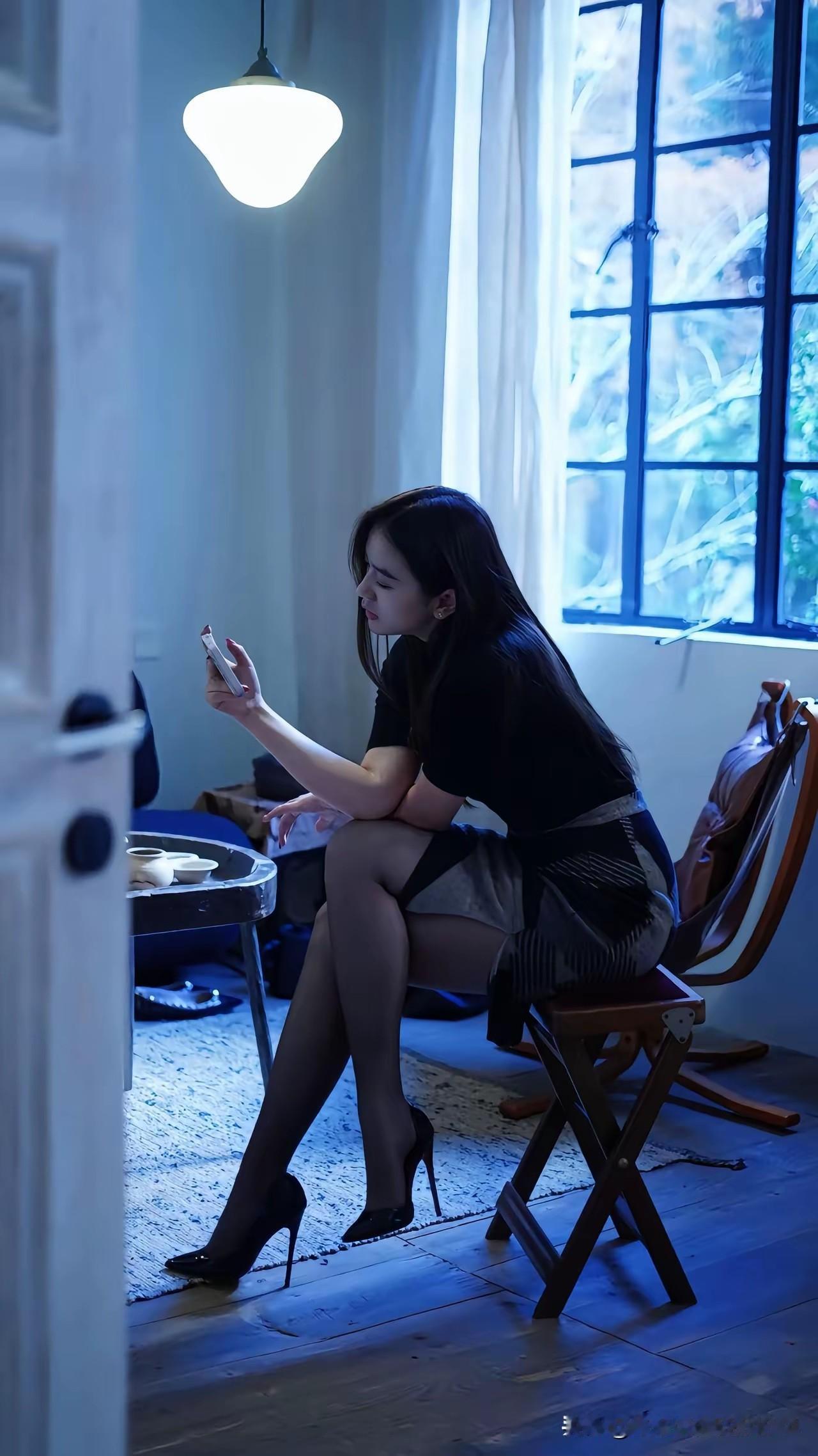 夜晚的静谧时光，独自一人，沉浸在手机的世界里，享受这宁静的夜晚。