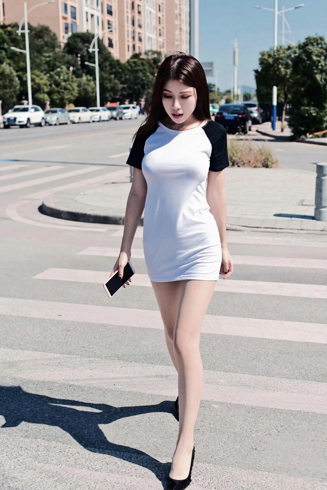 黄昏的雨后，雨声越来越急了，下班路上的行人纷纷寻地躲闪，唯有她手拿着包顶在头上，