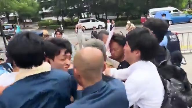 活该！一名精日台湾男子举着“我欢迎日本再次侵华”的牌子，头上还披着乌克兰国旗，像