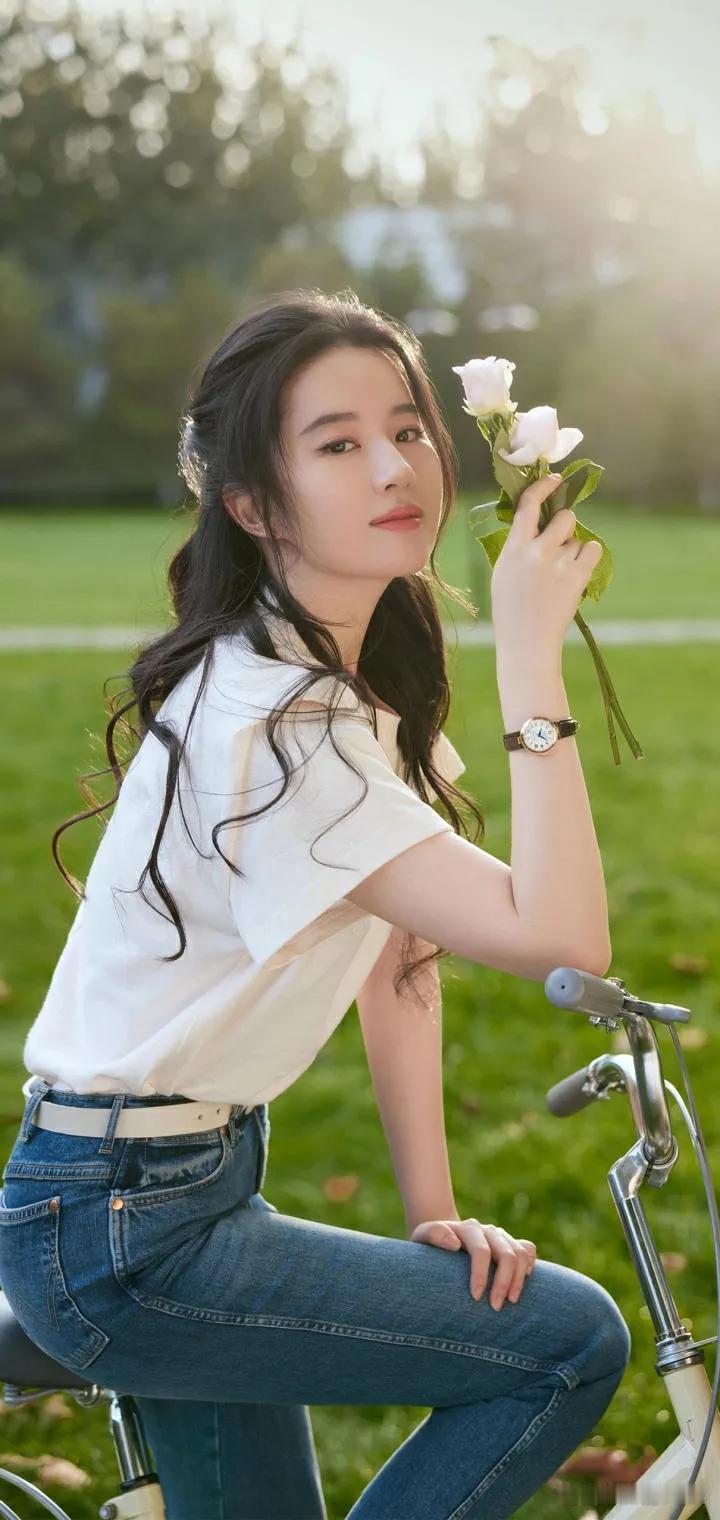 阳光下的少女，手捧鲜花，骑着单车，岁月静好。🌸🌞🚲