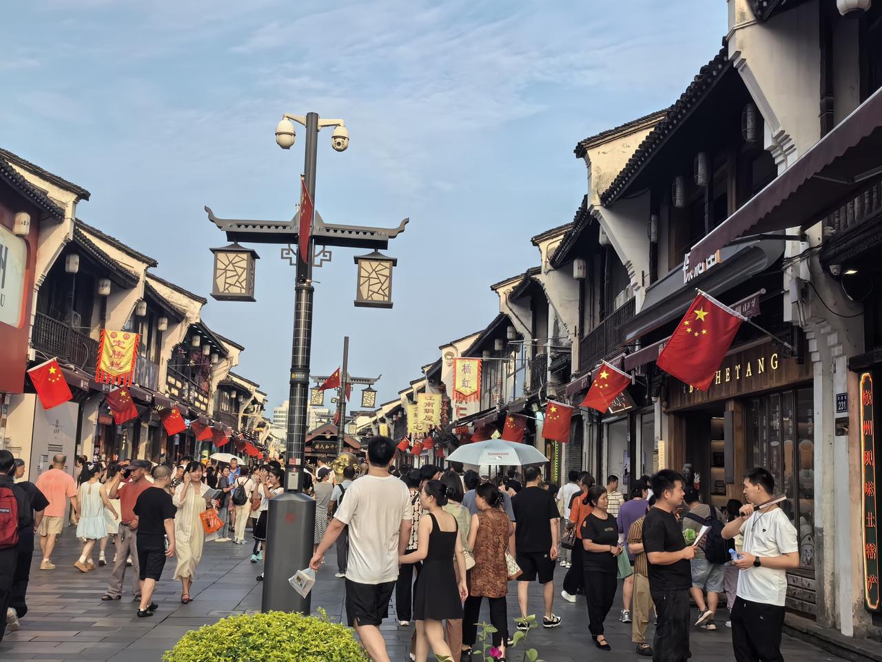 七律·河坊街国庆所见
粉墙黛瓦国旗红，
还活千年宋韵风。
酒旆铺前迎远客，
檐头