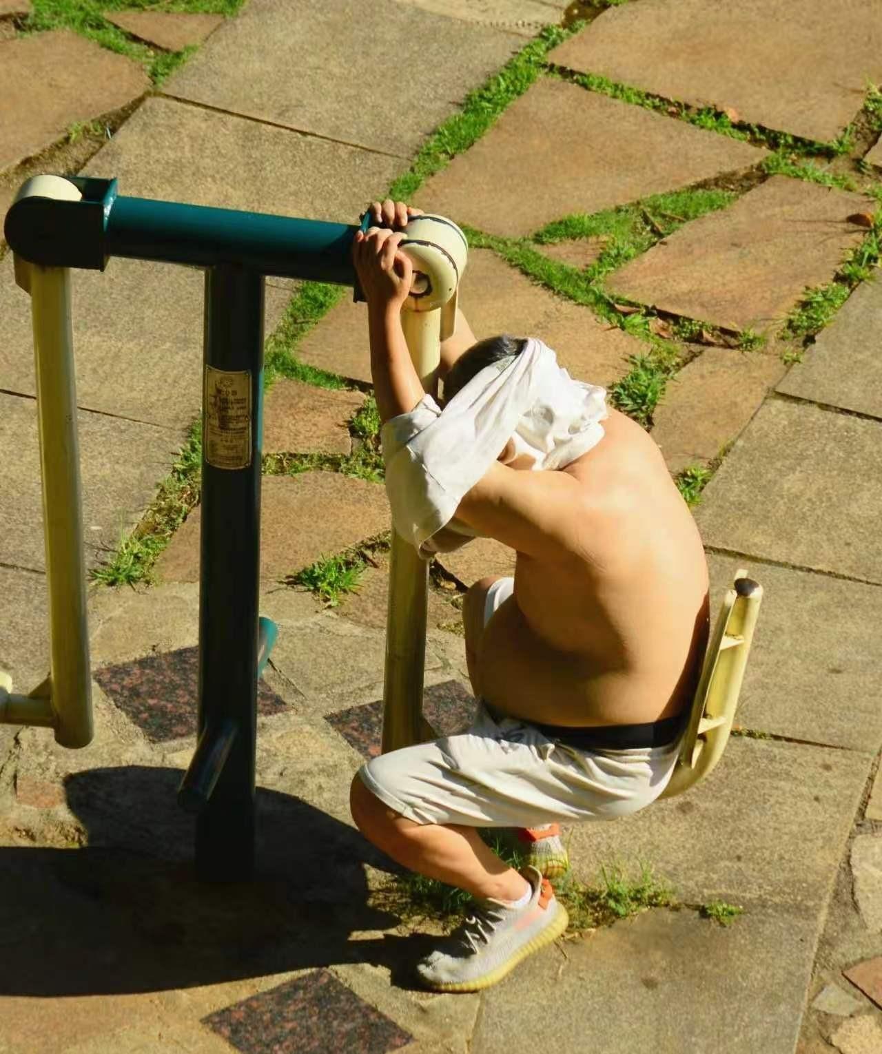 在火辣辣的太阳下晒湿气，相当于免费热疗，这人可能背难受，喜欢太阳帮他，增加阳气。