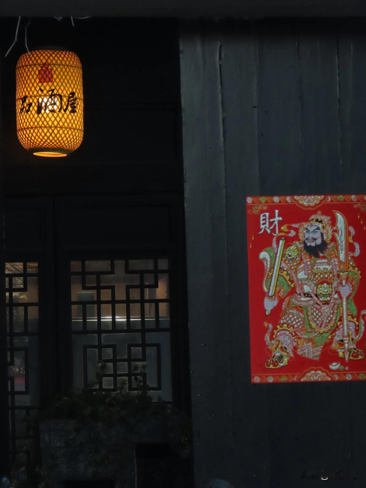 夜幕下的红灯笼与财神画，传统中国风韵十足。