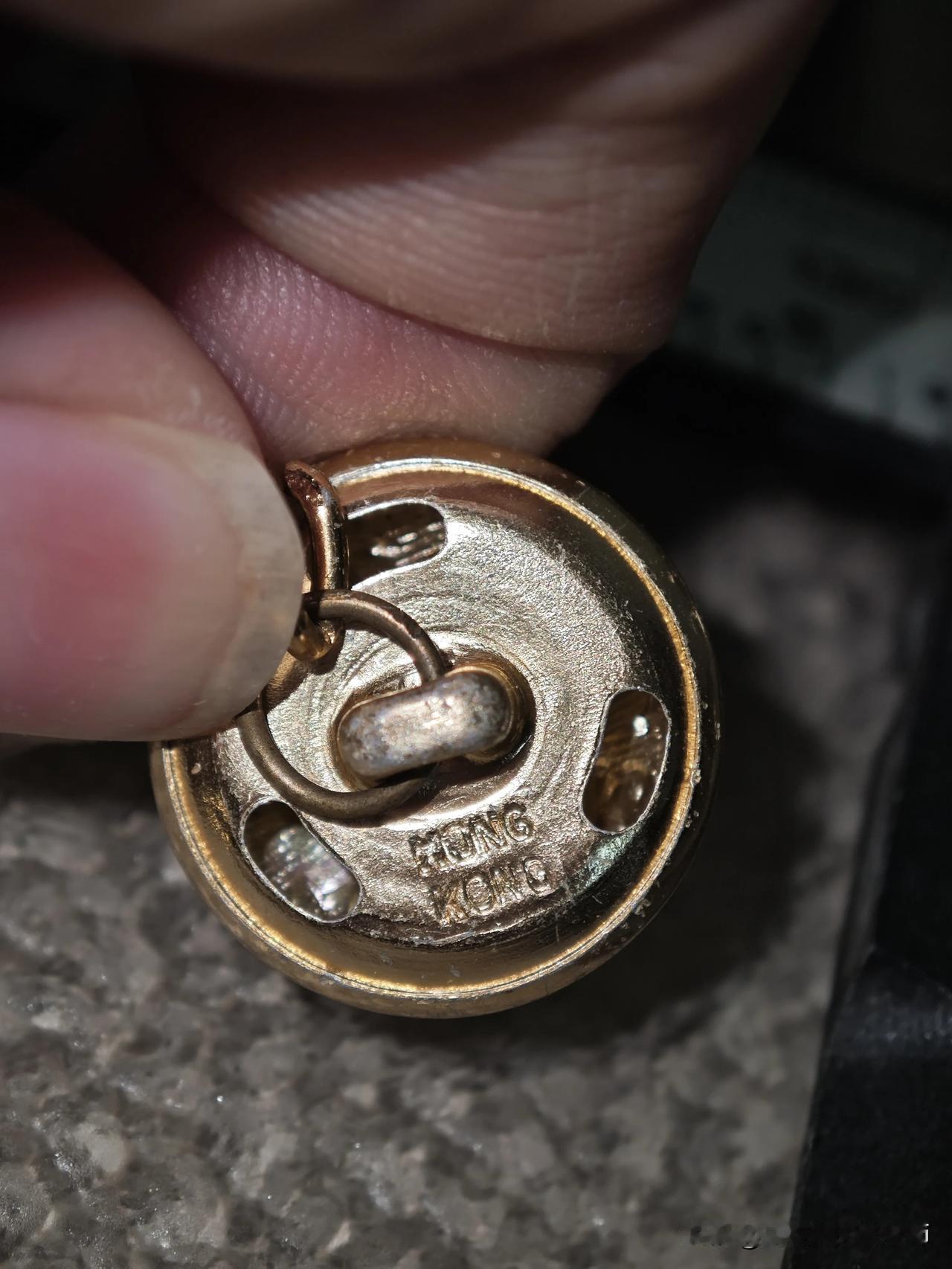 Kong落款，是当年香港代工生产的真实物证。纽扣采用铝质制作，搭配铜质链条，用料