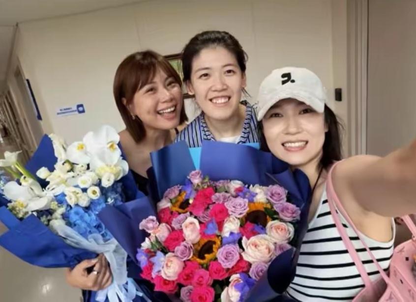 三位女排姑娘同框靓照：手捧鲜花的曾春蕾柔发覆额，凤眉皓齿，梨窝精致；穿着条纹衫的