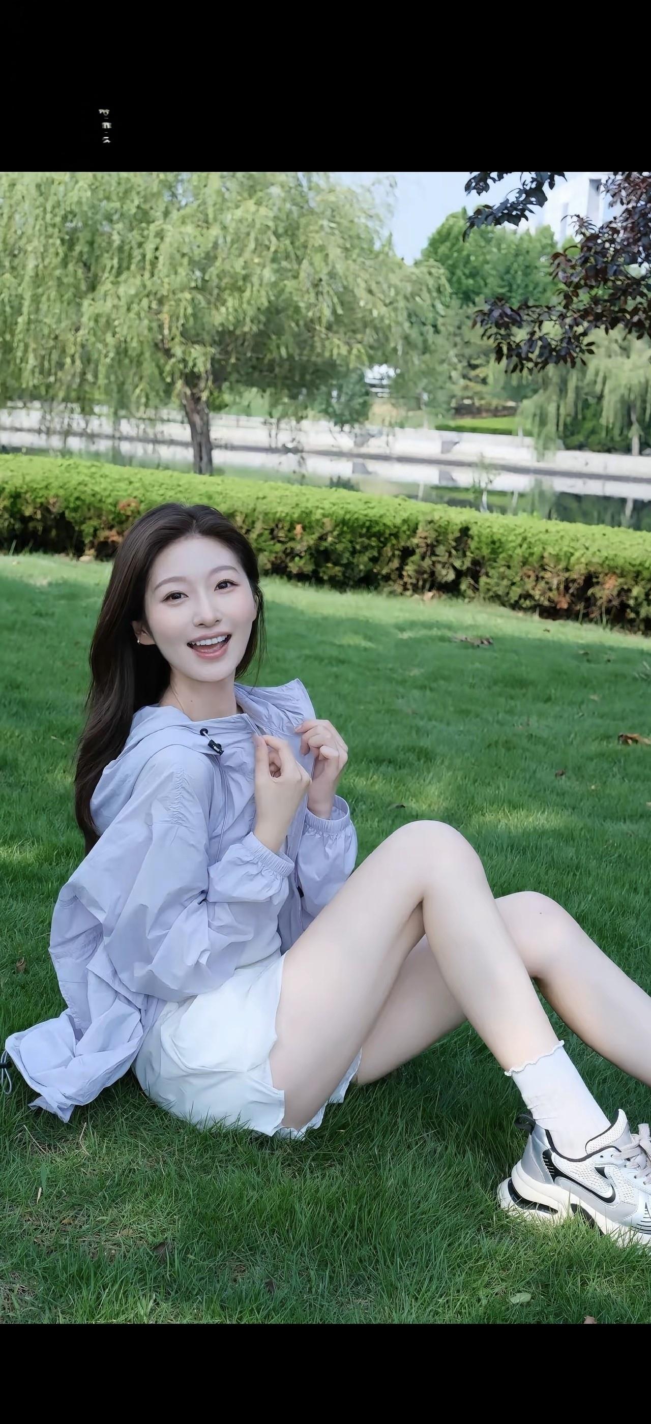 在公园草地上，女孩开心地微笑。