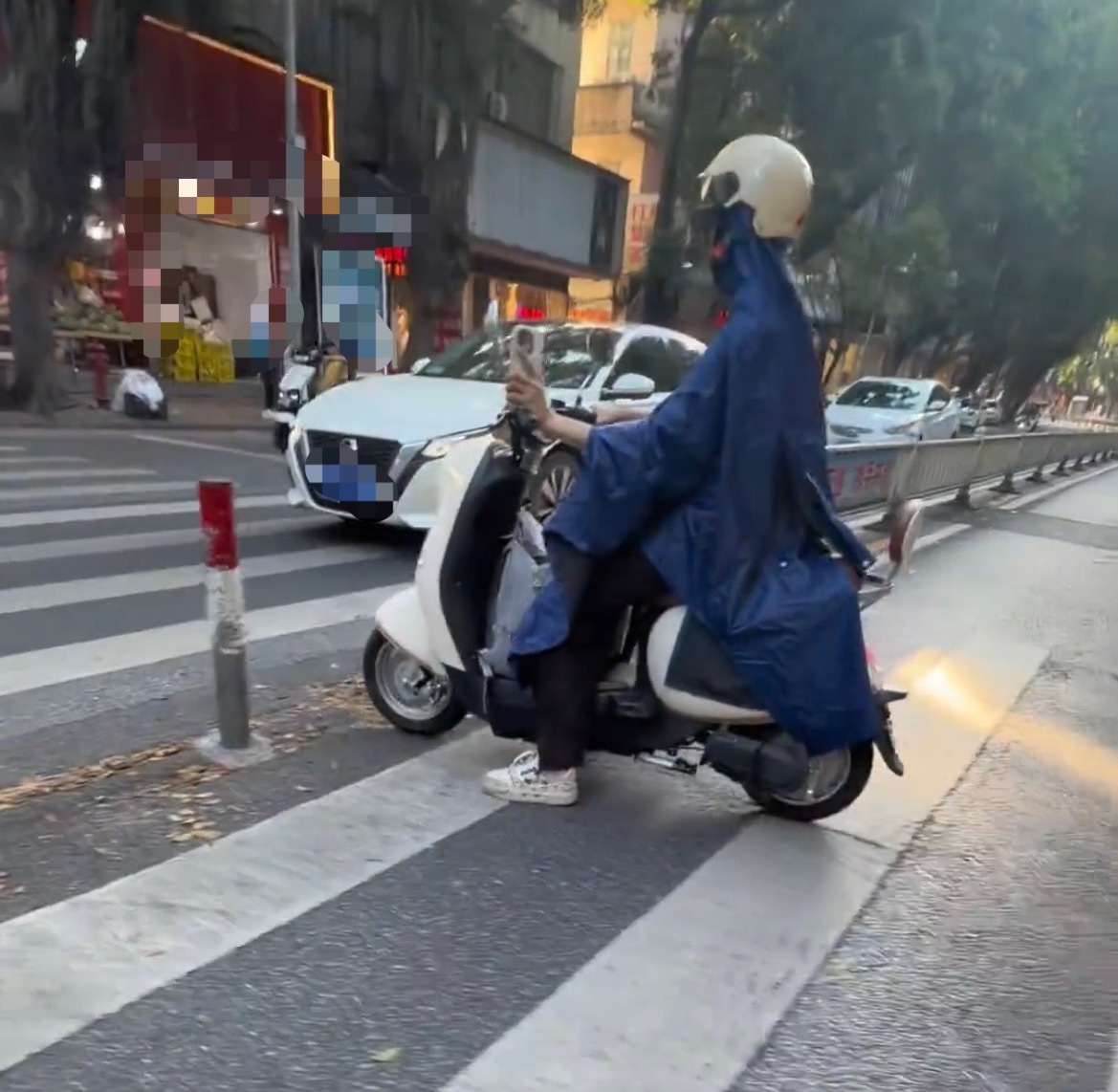近日，玉林城区一男子骑电动车穿雨衣防晒，这是怕晒黑了吗？还是不知道热？同城热点创